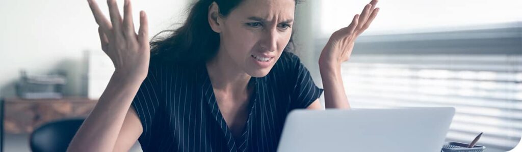 Une femme est frustrée et confuse devant son ordinateur portable